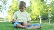stock-footage-boy-using-a-tablet-computer-outdoors.webp